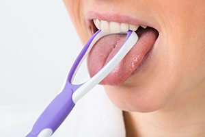 Woman Using a Tongue Scrapper