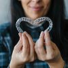 Patient Making Heart-Shape with Dental Aligners