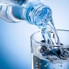 Bottle of Water Pouring Into Glass