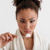 Woman Looking at Toothpaste